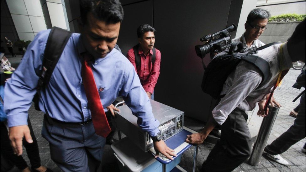 Malaysian plainclothes police carry a computer from the 1MDB (1 Malaysia Development Berhad) office after a raid in Kuala Lumpur, Malaysia, Wednesday, July 8, 2015.
