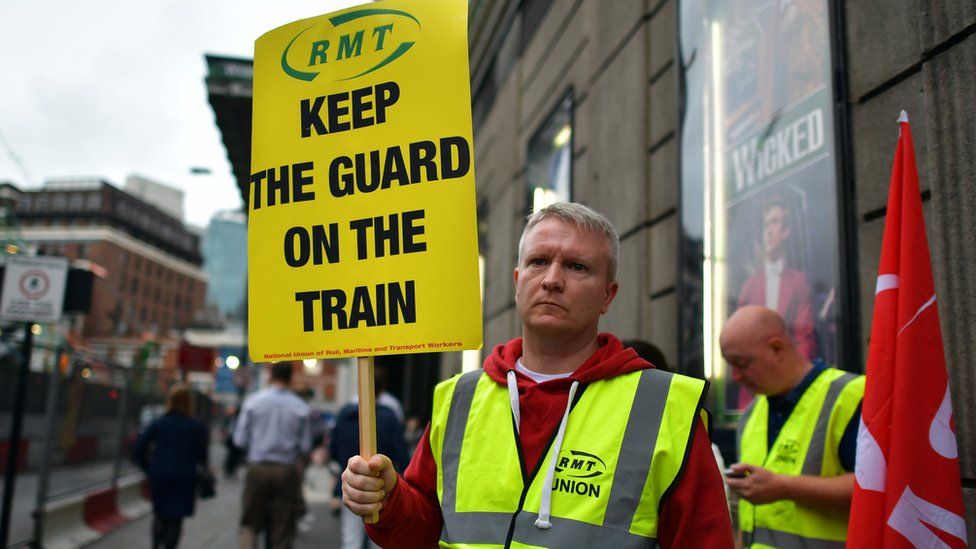 An RMT union member holds up a placard