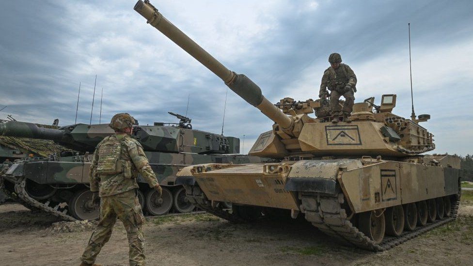 MAY 06, 2023: American soldiers are seen next to M1A2 Abrams tank during a high-intensity training session at the Nowa Deba training ground on May 06, 2023 in Nowa Deba, Poland. Anakonda-23 is the highlight of the Polish Army's training calendar this year.