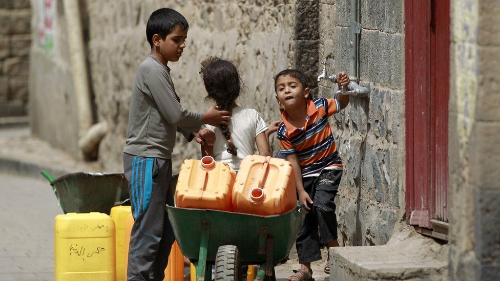 Yemeni children carry jerry cans to fill them with water amid an acute water shortage in Sanaa