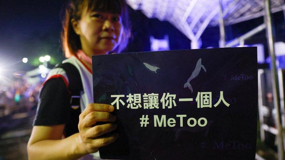 Женщина держит плакат в поддержку движения #MeToo