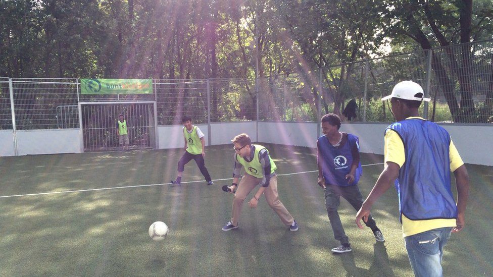 Штефан Пауэлл из Newsbeat играет в футбол с мигрантами в центре для беженцев Bayernkaserne в Мюнхене