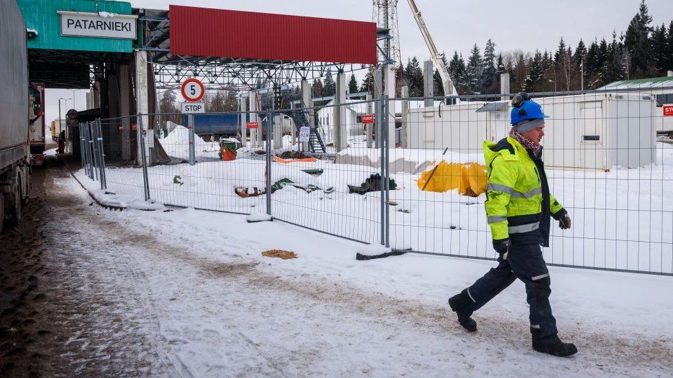 Рабочий идет возле стройки на латвийско-белорусской границе