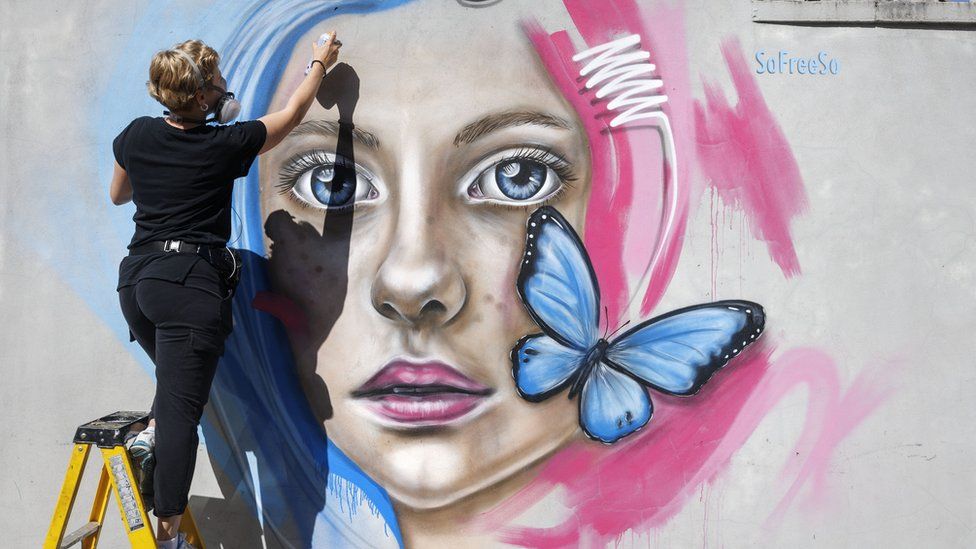Street artist SoFreeSo painting woman's face as part of Upfest in Bristol