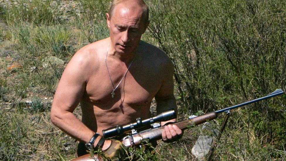 Vladimir Putin with a hunting rifle, pictured in 2007. The image is the July page on the 2018 Putin calendar.