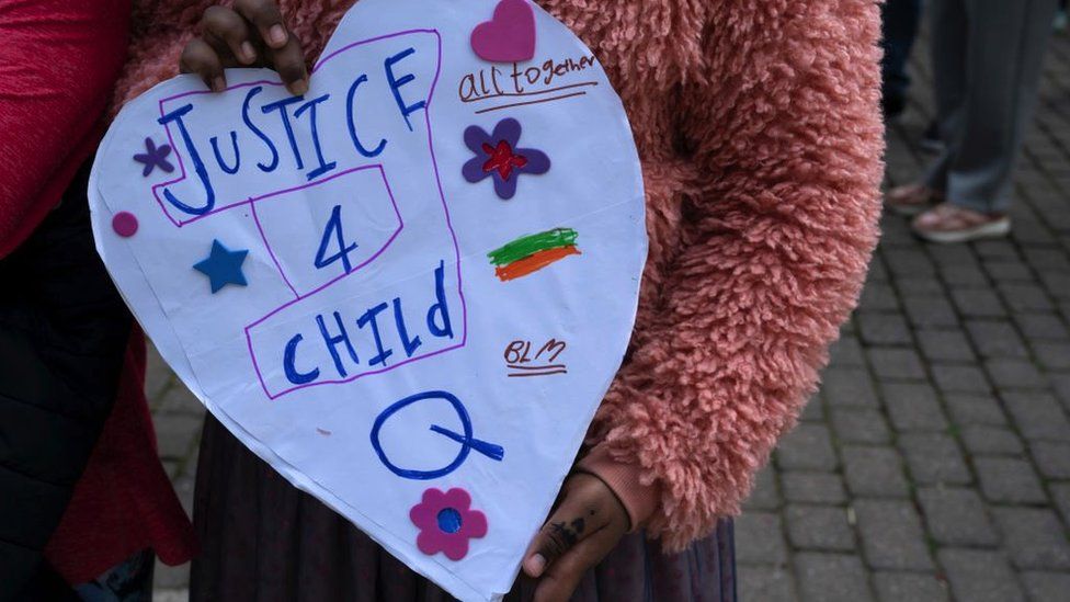 Girl holding a "justice for Child Q" sign