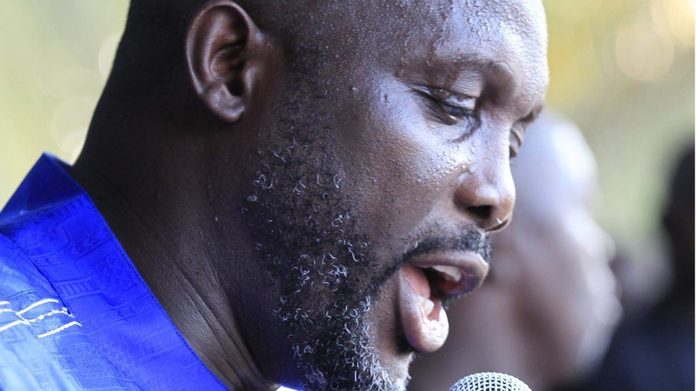 Close up of Mr Weah's face as he speaks into a microphone