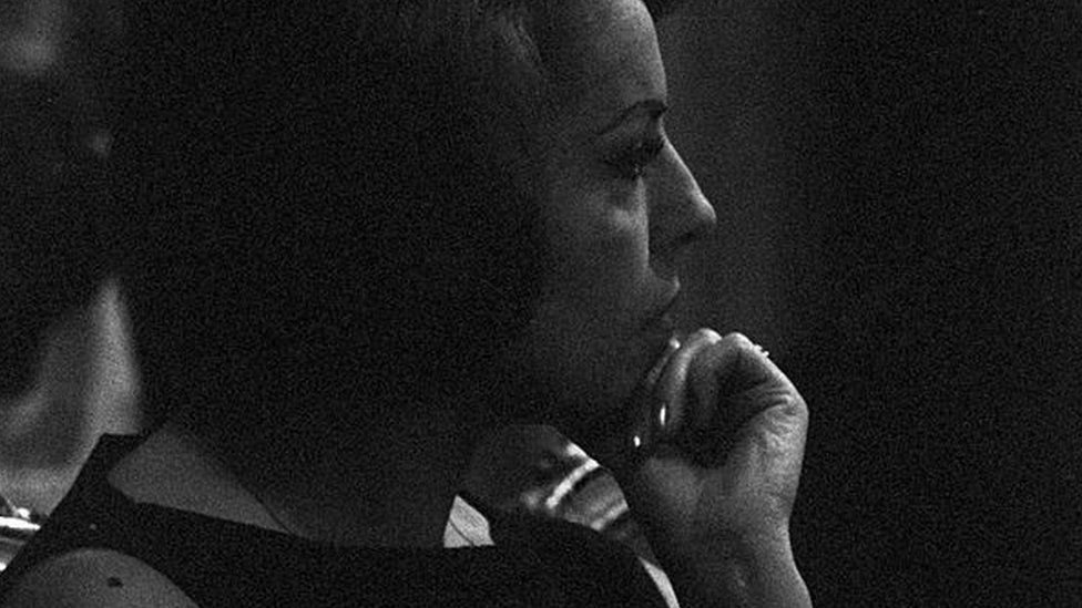 Close-up of the profile of the Chilean singer Matilde Urrutia, third wife of the Chilean poet Pablo Neruda (born Ricardo Eliezer NeftalÌ Reyes Basoalto), seated next to her husband during a reading of his poems by the Italian drama actor Giorgio Albertazzi. Italy, 1963.