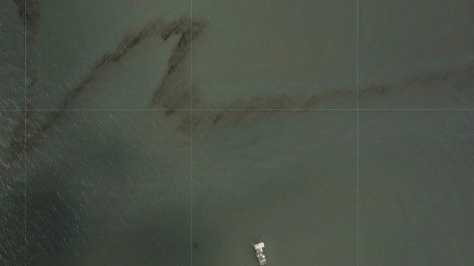 A dark trail appears on the waters of the Gulf of Mexico near an oil industry platform. Photo: 31 August 2021