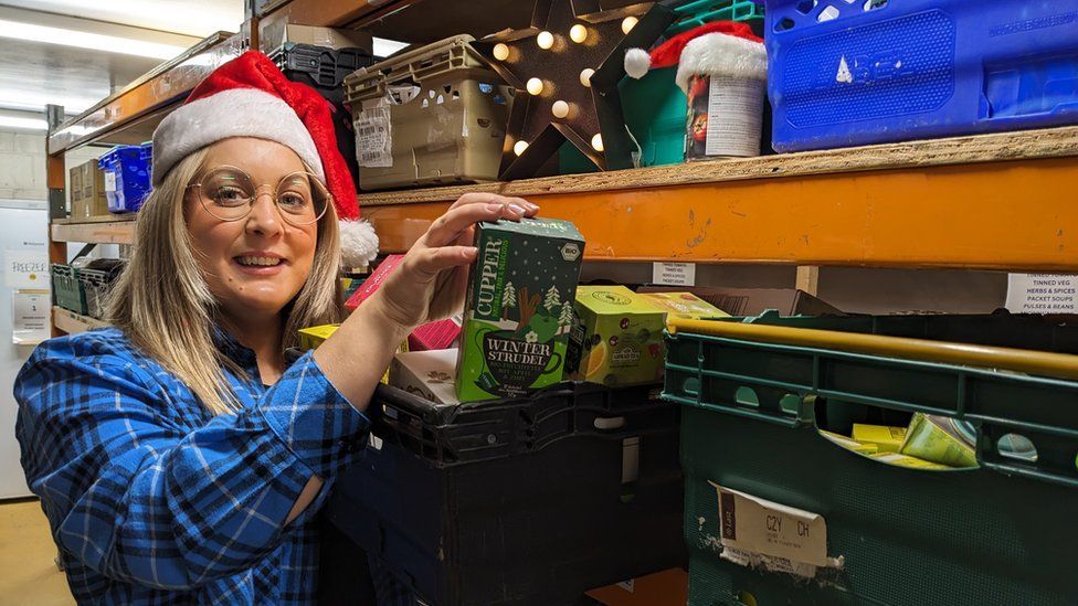 Abby Carter holding a box of tea in the store room of Caring in Bristol, where donations are kept