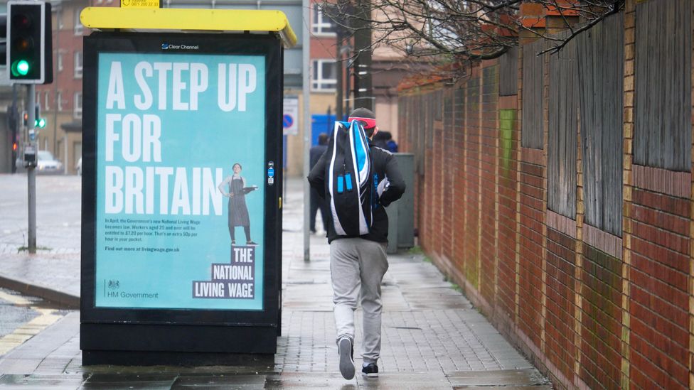 A bus stop in the city advertising the National Living Wage.