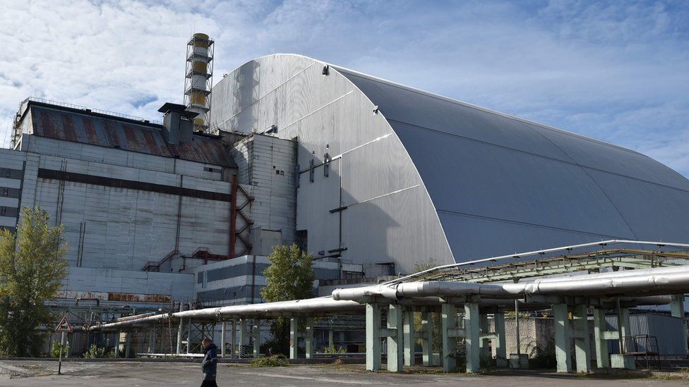 A man walks next to the New Safe Confinement over the fourth block of the Chernobyl nuclear plant in Chernobyl on 5 October 2018