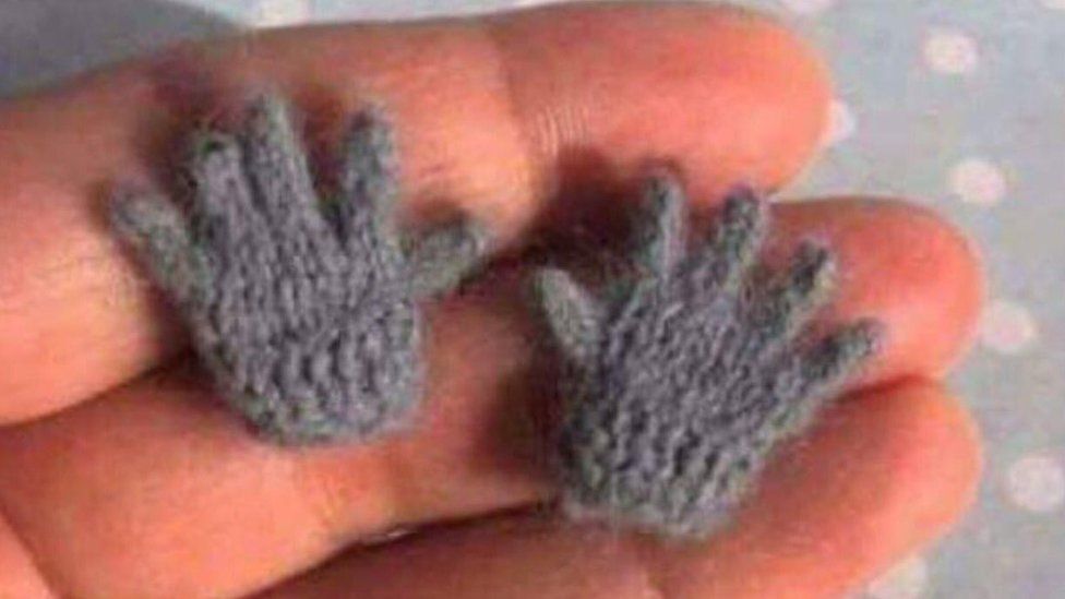 Hand holding small gloves
