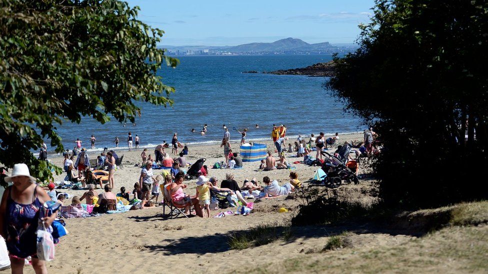 People enjoy the sun on Silver Sands beach at the start of the Scottish school holidays in 2018