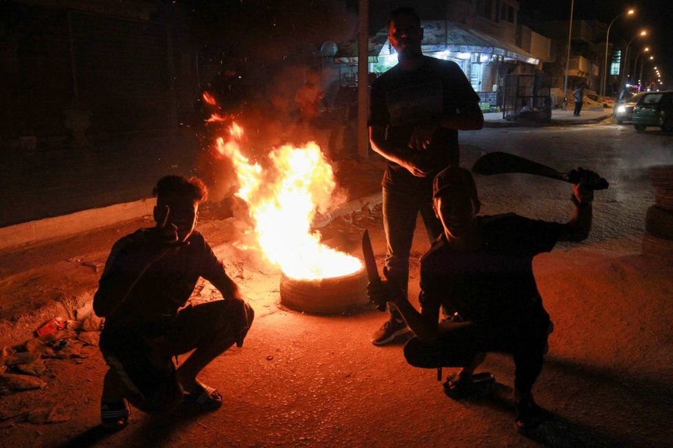 Young men block a road with burning tyres during protests in Libya's eastern coastal city of Benghazi on 12 September 2020.