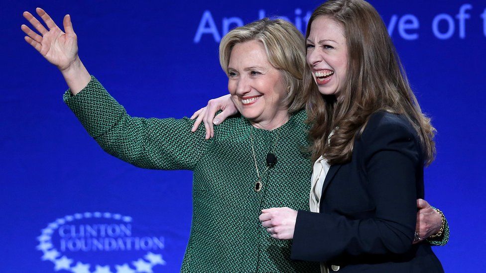 Hillary and Chelsea Clinton on stage at a Clinton foundation event, laughing and smiling