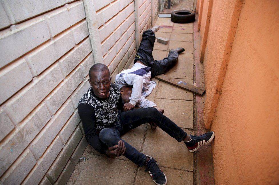 Suspects are handcuffed after breaking into a house belonging to married police officers, in Johannesburg, South Africa, 12 August 2015