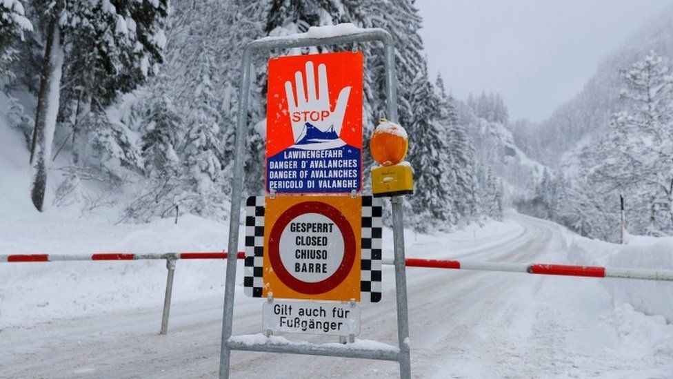 A sign warning of avalanche danger is seen on a closed road after heavy snowfall near Obertauern, Austria