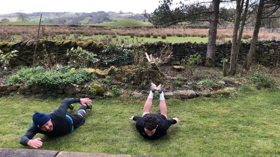 Andy Dickson swimming on the lawn with one of his sons