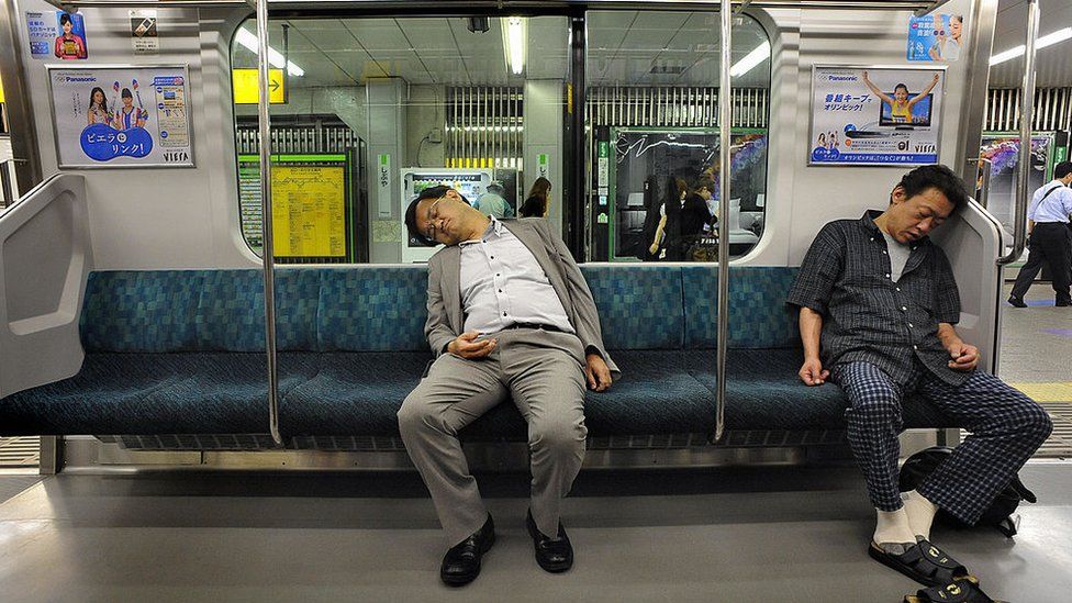 Two sleeping Japanese commuters on a train in Tokyo