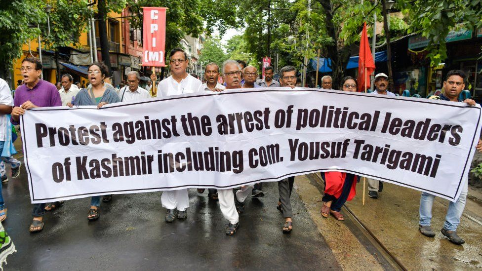 Members of the Left Front parties march with a banner during a protest rally against scrapping of Article 370 in Kolkata