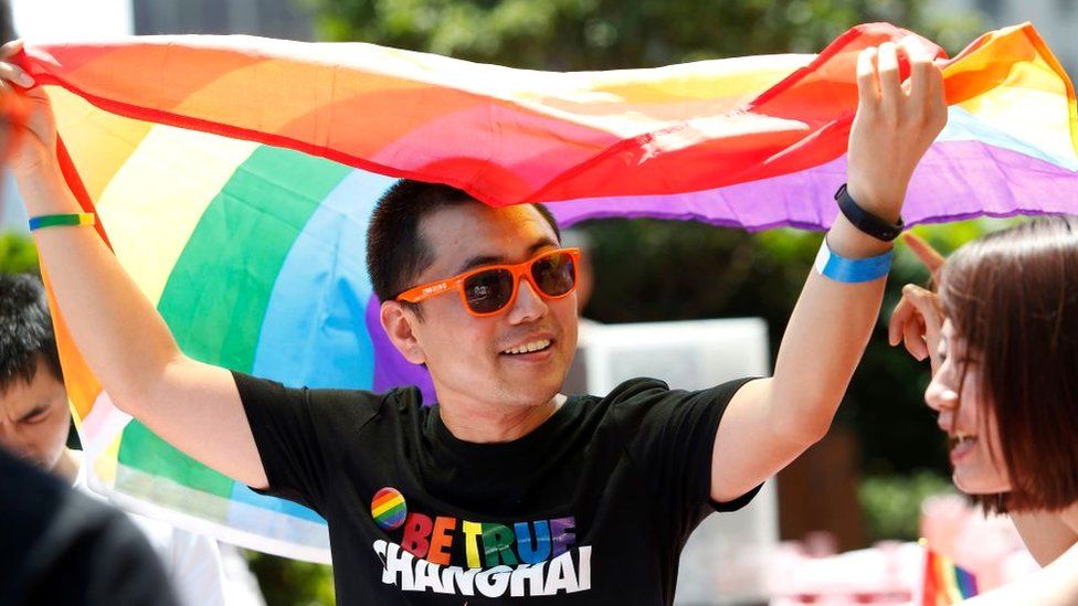 A man holds a rainbow flag after taking part in a Pride run in Shanghai in 2017.