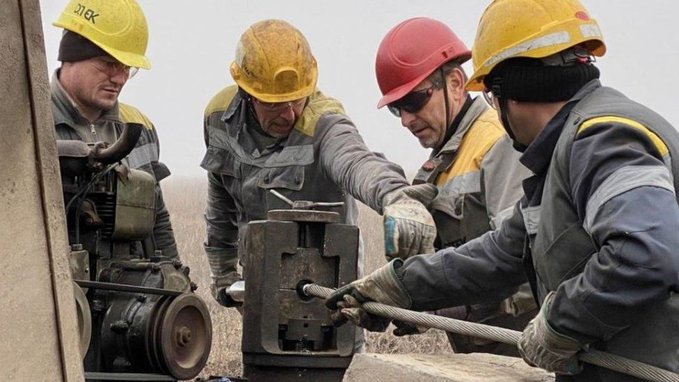 Four men in hard hats working