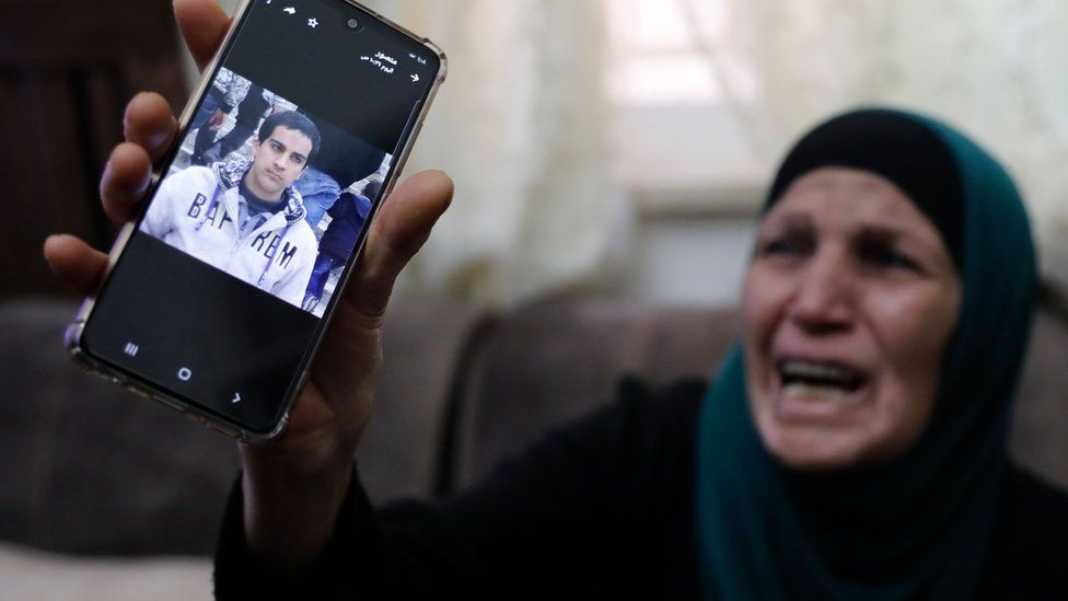 The mother of Iyad Halaq holds up a mobile phone photograph of him (30 May 2020)