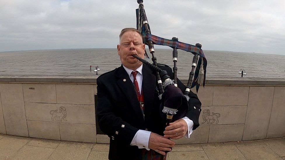 Daniel Fleming playing bagpipes on Cleethorpes beach
