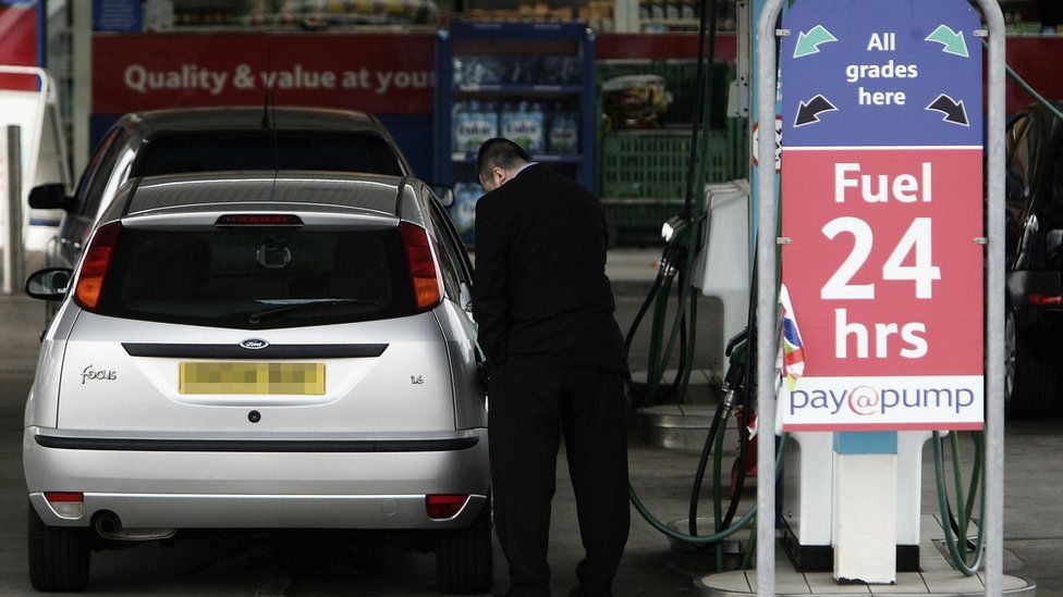 man fills car with petrol