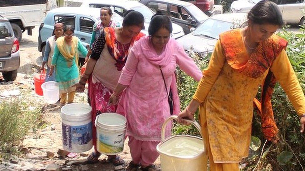 Women carrying buckets of water in Shimla