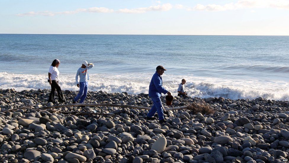 Volunteers search for more plane debris on the beach in Reunion. 31 July 2015