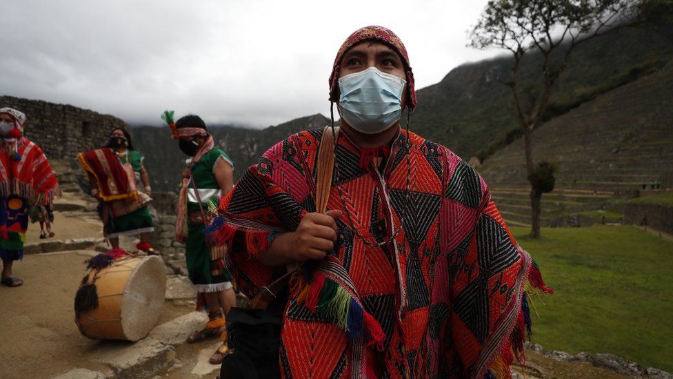 A person dressed in costume prepares for the ceremony to mark the reopening of Machu Picchu
