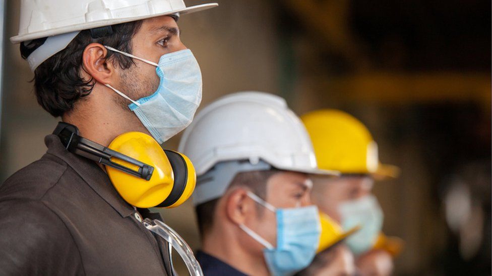 Machine workers wearing face masks