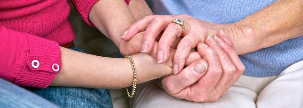 Young and elderly people holding hands