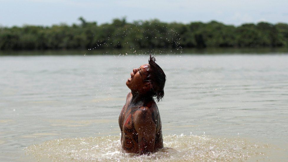 An indigenous man of Kuikuru tribe takes a bath on Xingu River