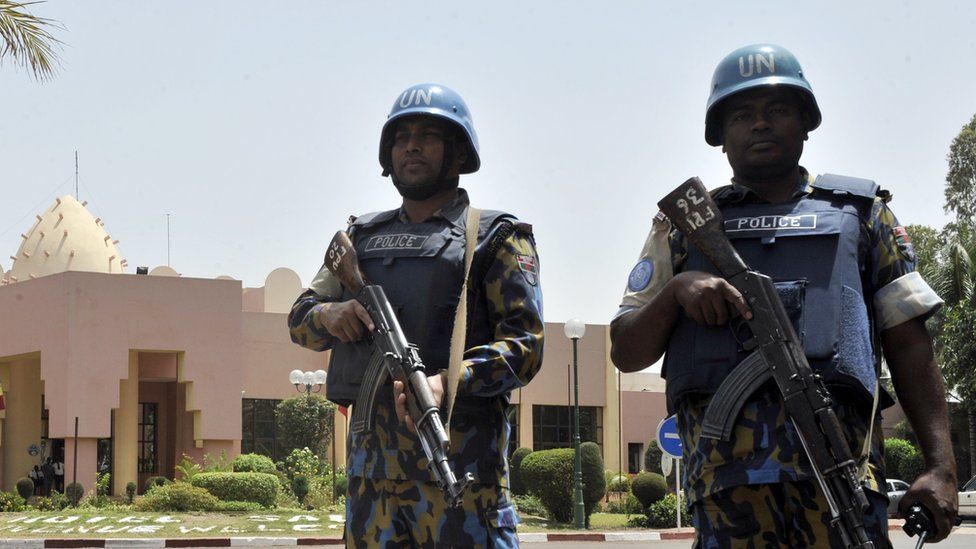 UN peacekeeper police officers stand guard at entrance of Hotel Salem in Bamako on March 8, 2015. T