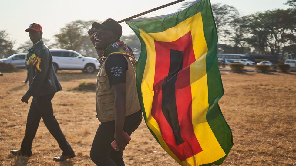 A supporter of Zimbabwe's president carries a Zanu-PF flag in Harare, Zimbabwe - 4 September 2023