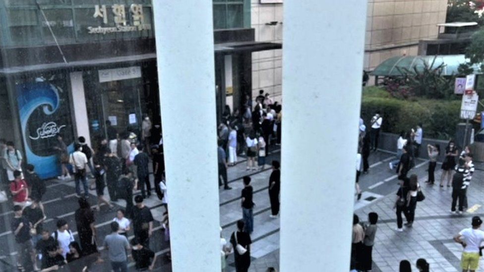 People stand outside Seohyeon station, near where the attack took place