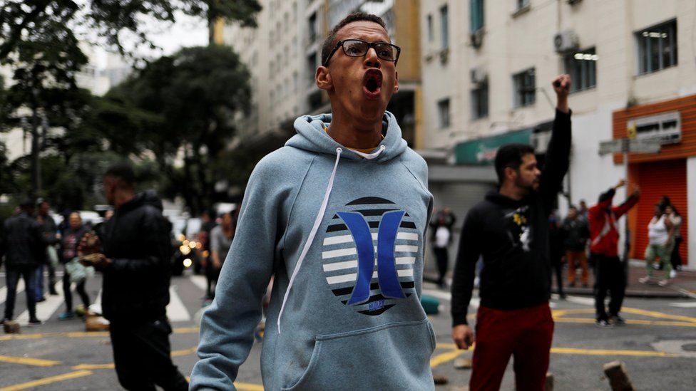 A protester shouts against police while blocking a road in Sao Paulo