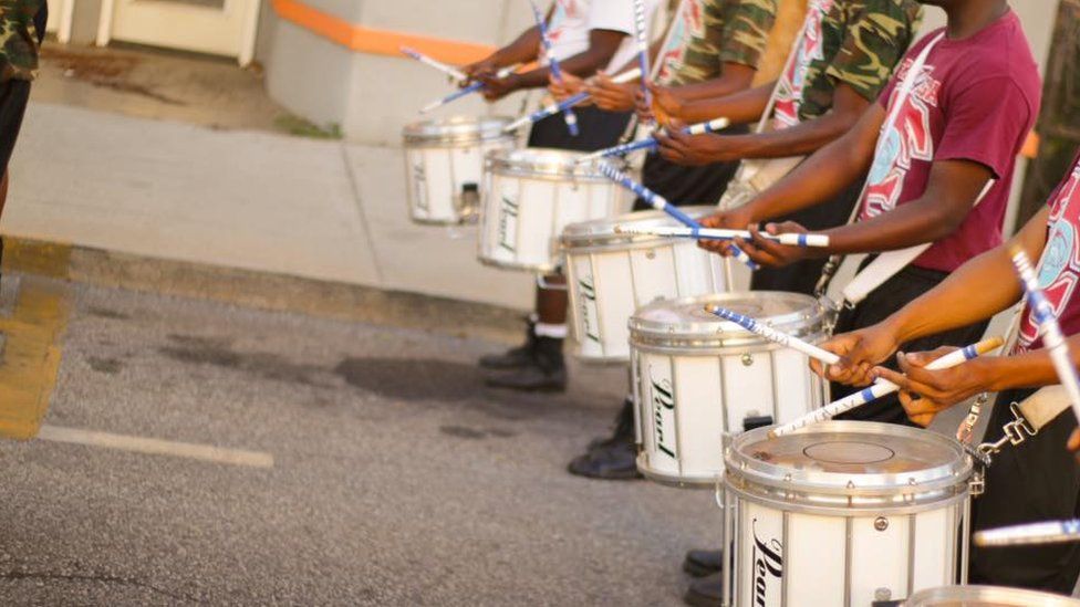 This is a photo of the Marching Tornados drumming in a parade.