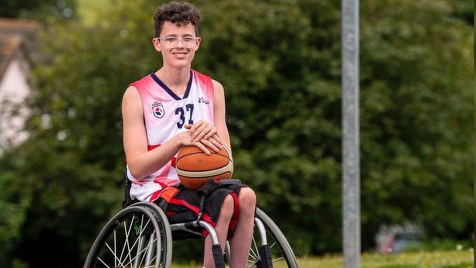 Oscar Knight holding basketball in wheelchair