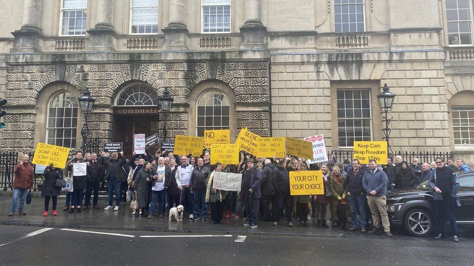 Protesters outside Bath's Guildhall holding placards