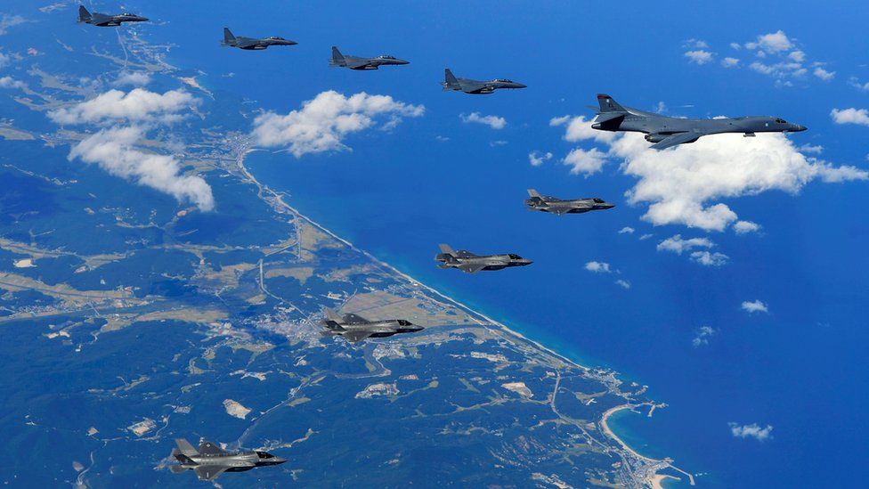 A US Air Force B-1B Lancer bomber (R), US F-35B stealth jet fighters (bottom) and South Korean F-15K fighter jets (top) flying over South Korea during a joint military drill