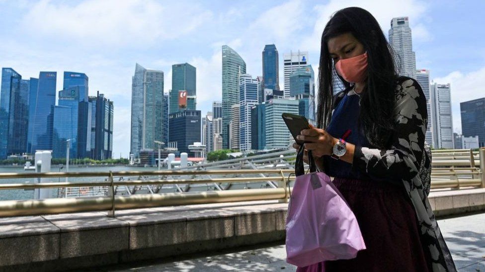 Woman on mobile phone in front of Singapore skyline