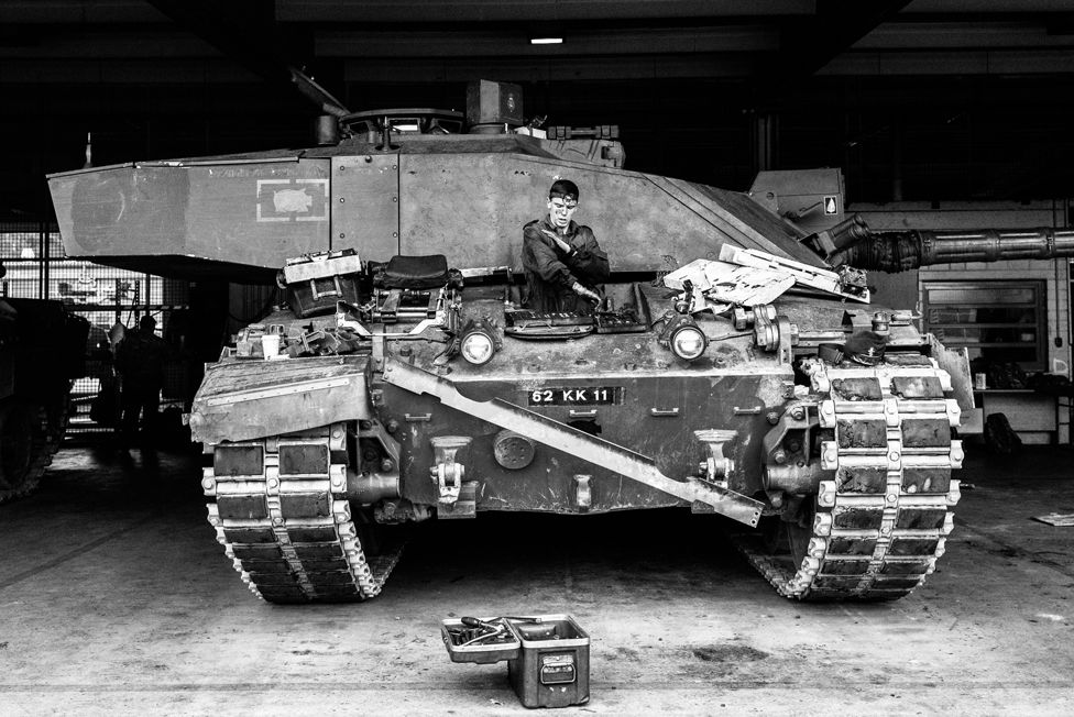 Corporal Aaron Drury of D Squadron, The Queen's Royal Hussars removes equipment from a tank driving compartment to use on other vehicles. Athlone Barracks, Sennelager, Germany, November 2018