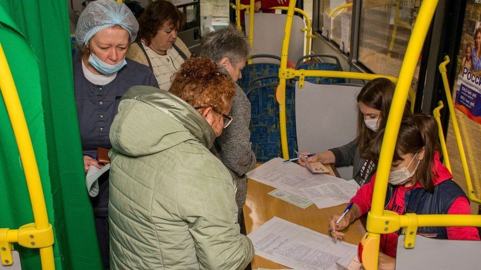 Women line up to cast vote in referendums on bus.