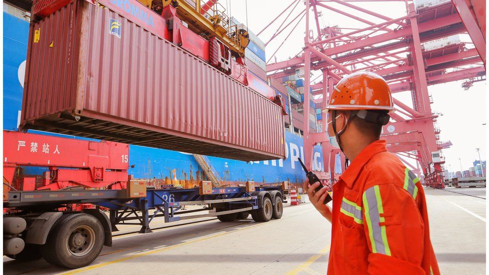 Рабочий руководит погрузкой контейнеров на контейнерном терминале в Ляньюньгане, провинция Цзянсу, 26 июня 2022 г.