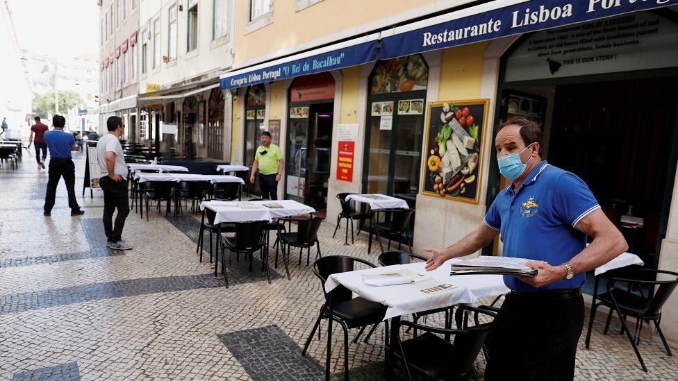 A waiter waits for customers at a restaurant, amid the coronavirus disease (COVID-19) outbreak, in downtown Lisbon, Portugal May 25