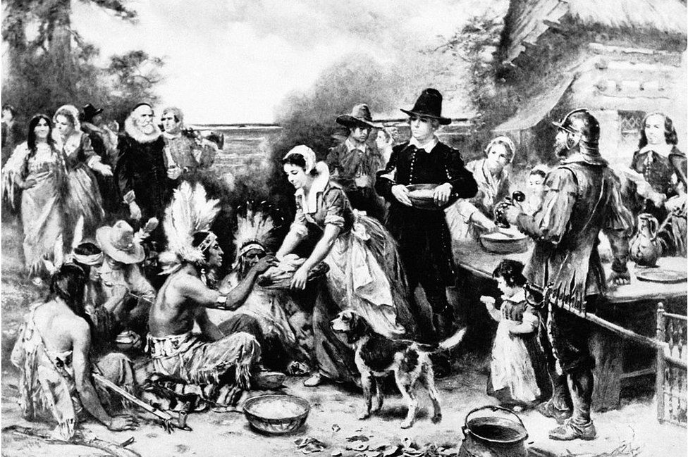 An artists depiction of the first Thanksgiving meal, featuring Native Americans